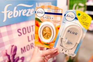 Febreze small spaces and plug held up in front of Febreze sign in Walmart store