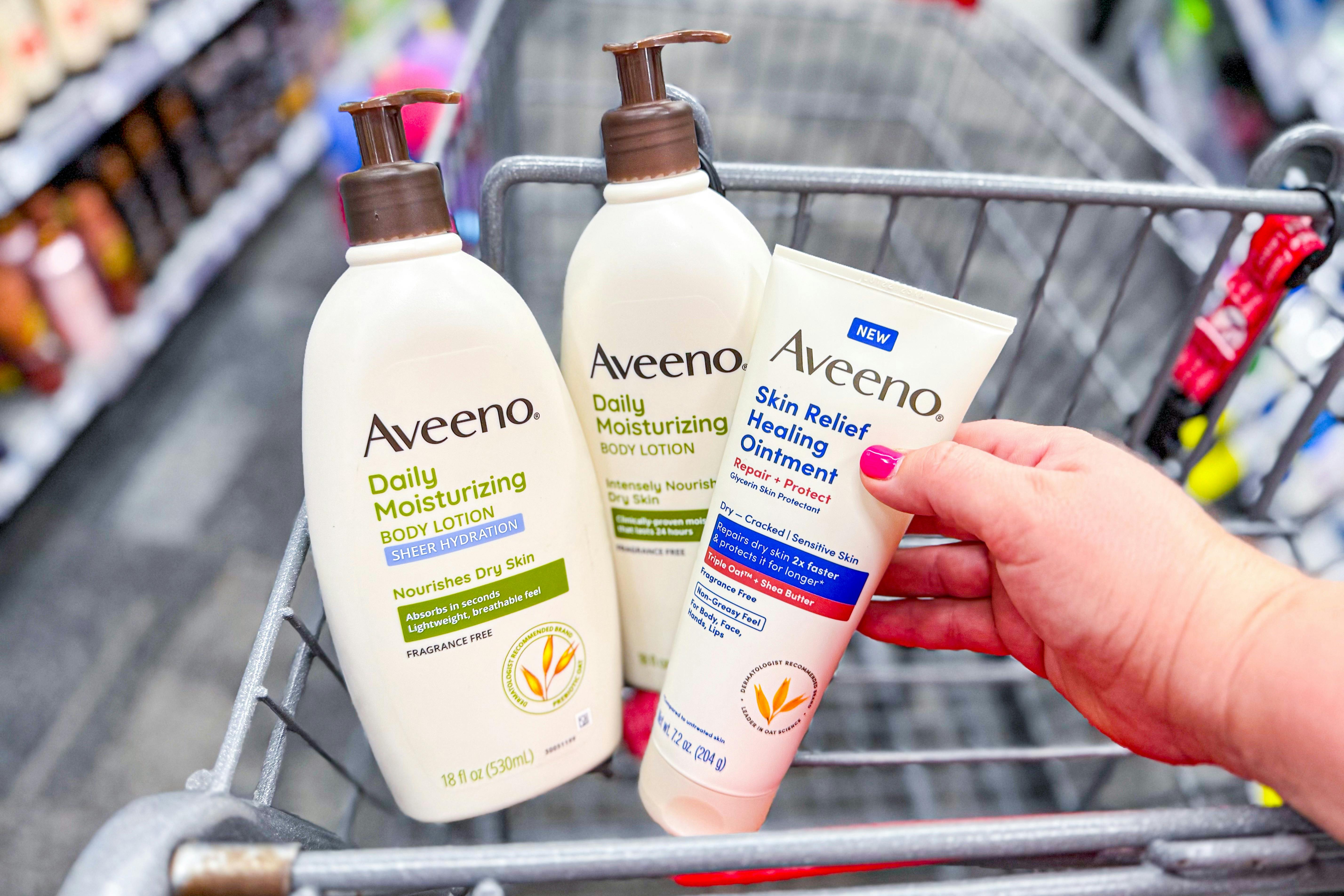 hand holding aveeno lotions in a shopping cart
