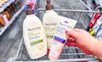 hand holding aveeno lotions in a shopping cart