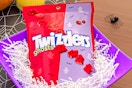 Lifestyle image of the Twizzler Ghosts Cherry Flavored Chewy Halloween Candy Bag in purple basket