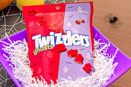 Lifestyle image of the Twizzler Ghosts Cherry Flavored Chewy Halloween Candy Bag in purple basket