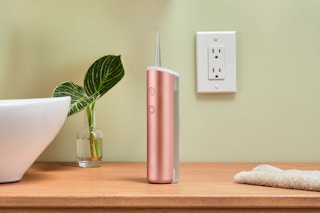 pink quip water flosser on a bathroom counter