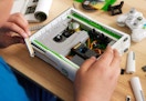 person building the Xbox 360 replica with brick blocks