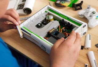 person building the Xbox 360 replica with brick blocks