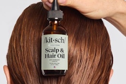 a woman holding kitsch hair oil
