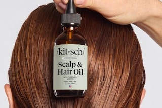 a woman holding kitsch hair oil