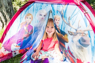 stock photo of little girl playing in disney frozen 2 no floor dome tent in grassy yard