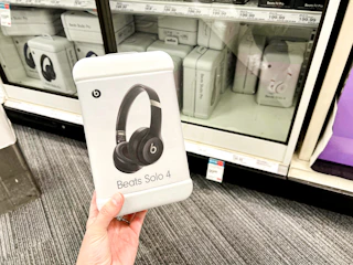 a woman wearing light pink Beats headphones