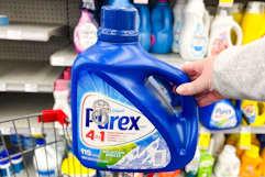 person holding a bottle of purex detergent