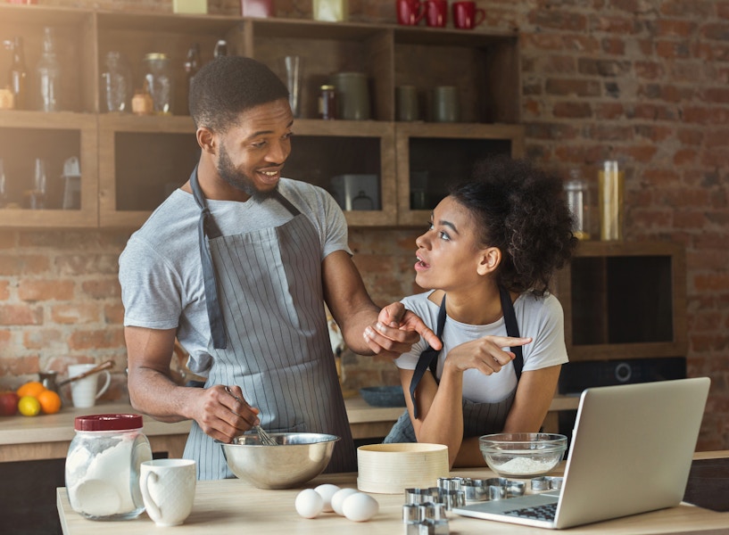 A couple taking an online cooking class and getting ready to try the recipe