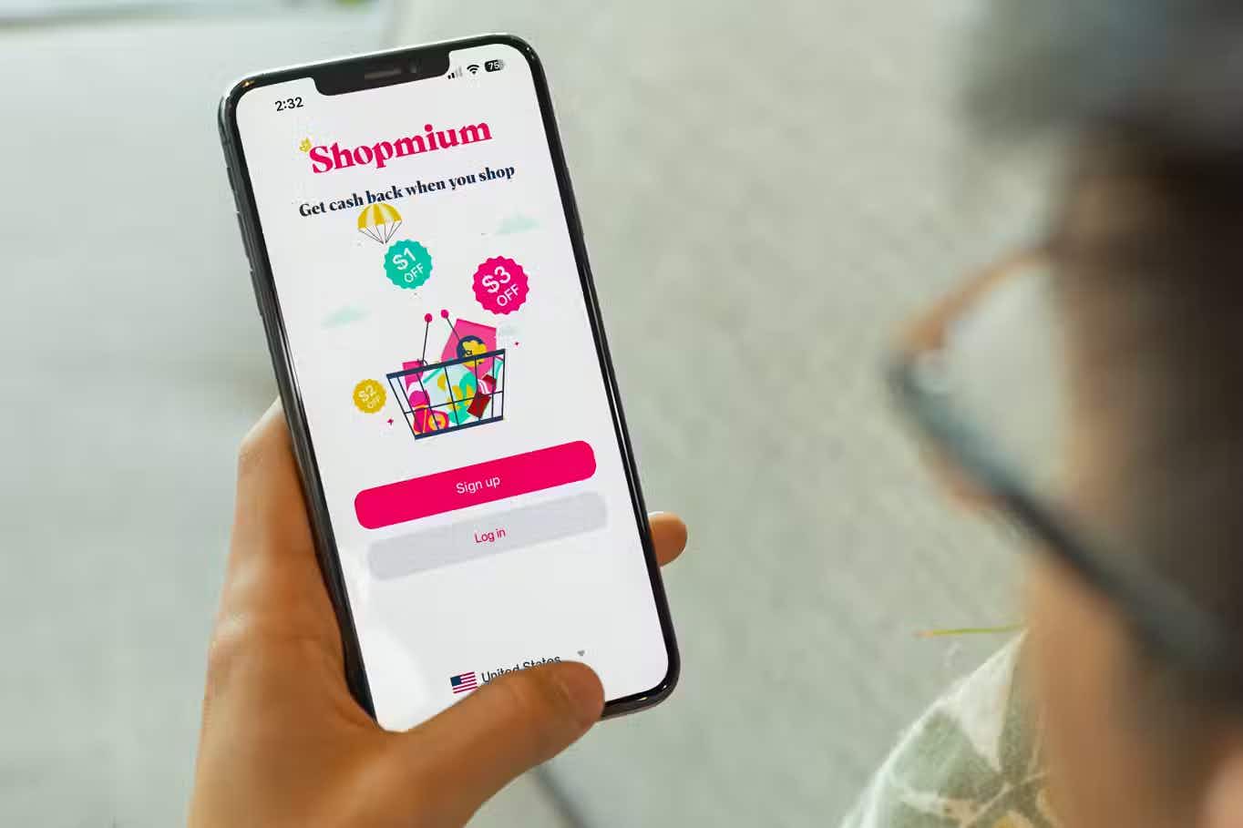 someone holding a phone displaying the shopmium app