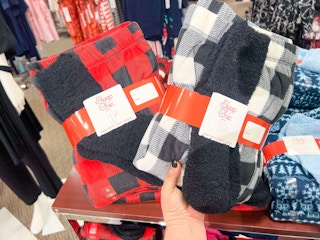 someone holding a pj set that comes with fuzzy socks