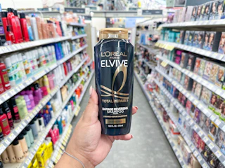 hand holding l'oreal elvive shampoo in walgreens