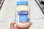 hand holding a jar of Hellman's light mayonnaise