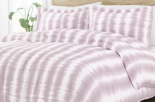 a purple and white duvet cover on a bed