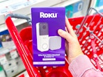 hand holding a roku video doorbell in front of a target cart