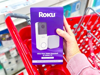 hand holding a roku video doorbell in front of a target cart