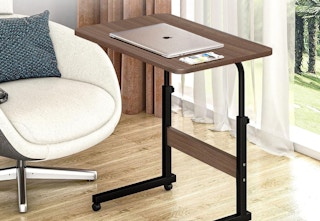 a brown adjustable desk with a laptop on top of it