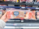 hand holding a pack of wright brand bacon in walmart aisle
