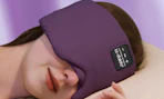 a person sleeping with a purple headphones sleep mask 