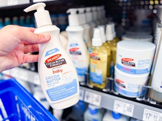 hand holding a bottle of palmers baby lotion in walmart aisle