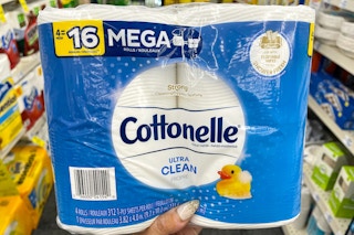 hand holding package of cottonelle bath tissue in aisle