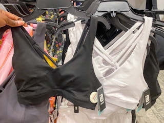 hand holding black in front of a white id low impact sports bra