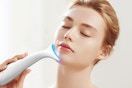 a woman using a facial massager