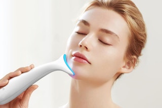 a woman using a facial massager