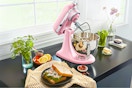 Lifestyle image of a pink KitchenAid Deluxe Series 4.5-Quart Tilt Head Stand Mixer in kitchen setting