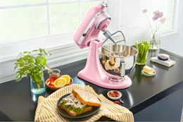 Lifestyle image of a pink KitchenAid Deluxe Series 4.5-Quart Tilt Head Stand Mixer in kitchen setting
