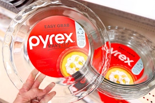 hand holding a pyrex pie pan in front of a target shelf