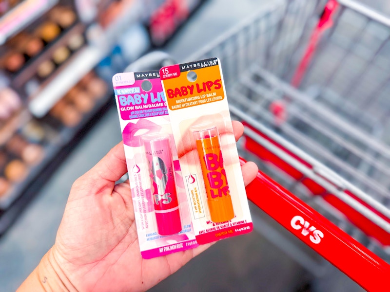 person holding 2 maybelline baby lips by a cvs cart