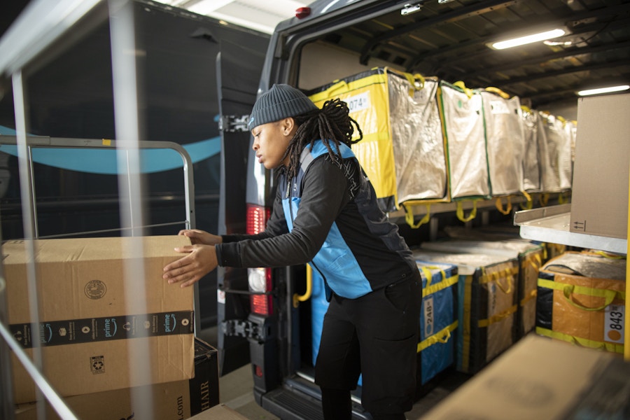 an amazon delivery driver packing boxes onto truck