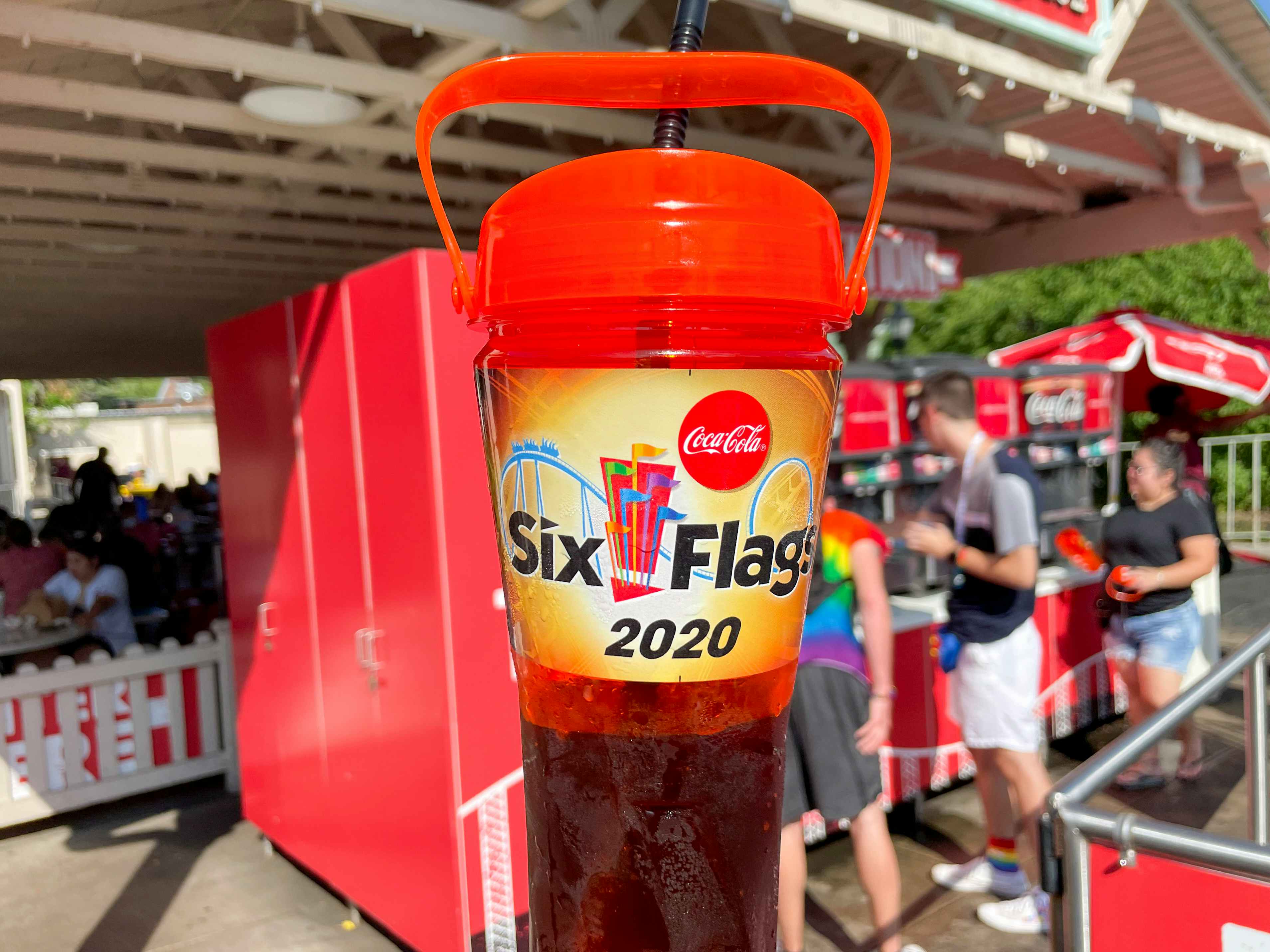 Six flags refillable soft drink cup held in front of a drink station