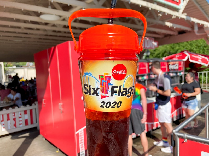 Six flags refillable soft drink cup held in front of a drink station