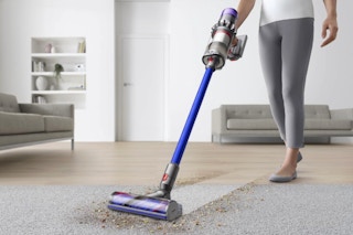 Woman using the Dyson V11 Origin Cordless Vacuum.