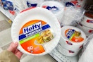 hand holding a pack of hefty foam plates