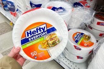 hand holding a pack of hefty foam plates