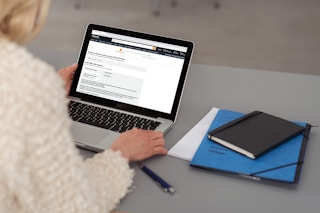 a person looking at a laptop with amazon prime pulled up