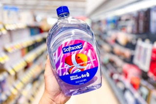 person holding a softsoap refill in an aisle