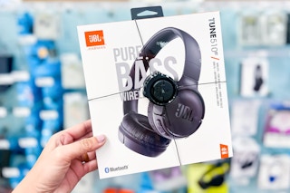 Holding JBL Tunes Headphones up with blurred background in store shot