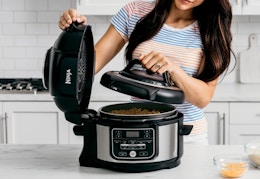 person cooking with the Ninja Food pressure cooker in a kitchen