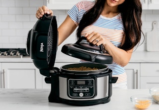 person cooking with the Ninja Food pressure cooker in a kitchen