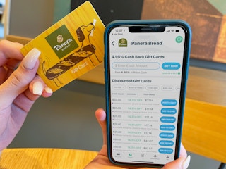 A cell phone displaying Raise.com held next to a gift card.