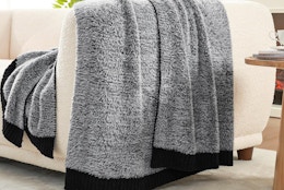 a black and grey fuzzy blanket on a couch
