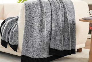 a black and grey fuzzy blanket on a couch
