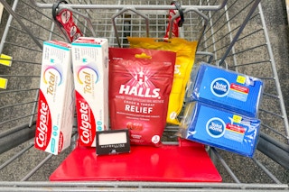 colgate toothpaste, halls cough drops, sponges, and maybelline eyeshadow in a cart