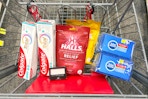 colgate toothpaste, halls cough drops, sponges, and maybelline eyeshadow in a cart