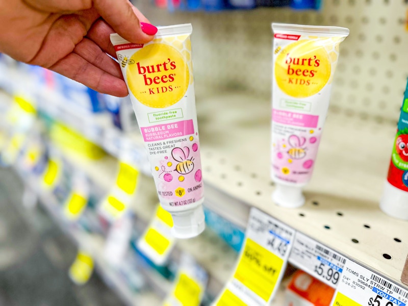person grabbing burts bees kids toothpaste off the shelf